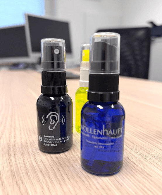 Pflegespray in kleinen Fläschchen in schwarz, blau und gelb für Hörsysteme