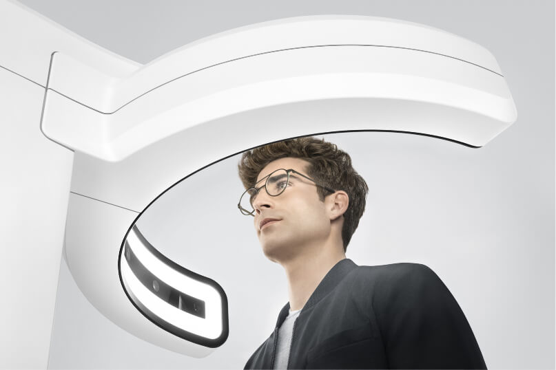 Visufit1000-Ansicht von unten Mann mit dunkelbraunen Haaren und dunkler Brille sitzt vor einem optischen Messgerät