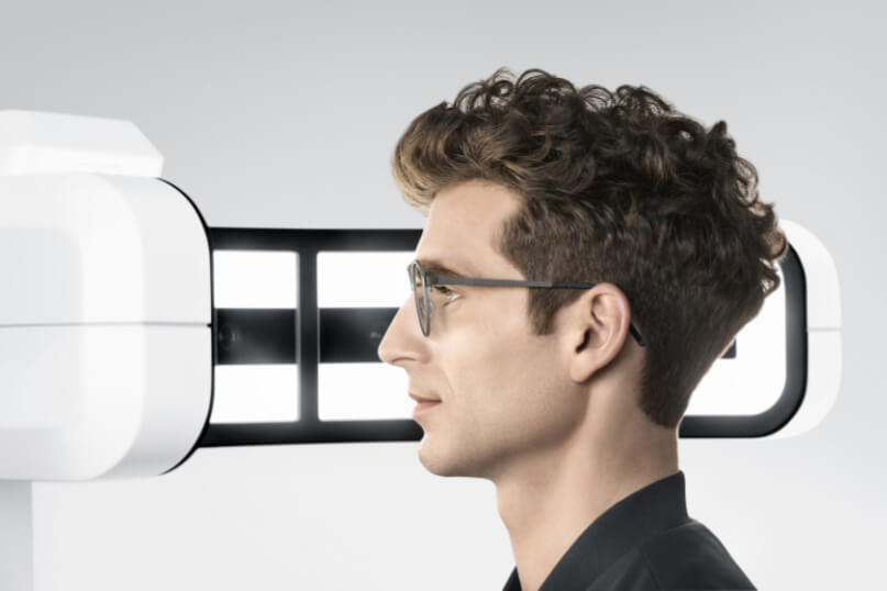 Visufit1000-Seitenansicht Mann mit dunkelbraunen Haaren und dunkler Brille sitzt vor einem optischen Messgerät